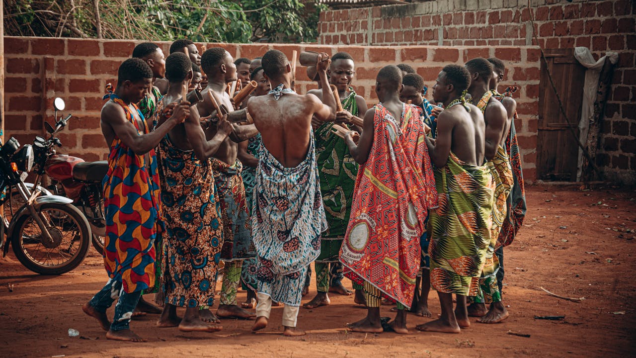A vibrant cultural ceremony in Benin featuring a group in traditional clothing engaging in a ritual dance.