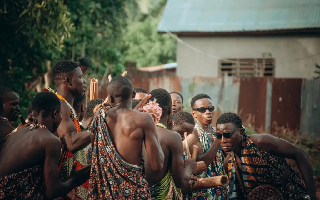 Group of men in traditional clothing performing a cultural dance in Abomey Calavi, Benin.