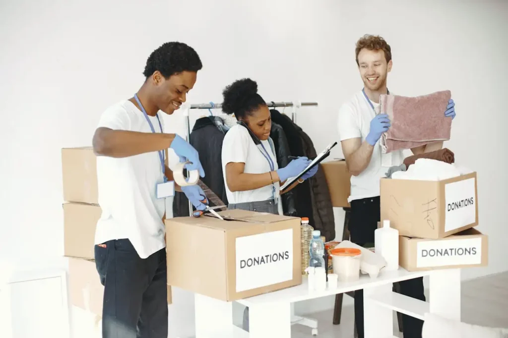 Mission Diverse volunteers happily sorting donation boxes indoors during a charity event.